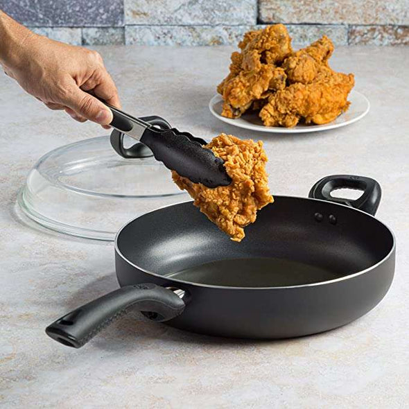 Evolve Chicken Fryer with High Dome Glass Lid putting fried chicken in fryer
